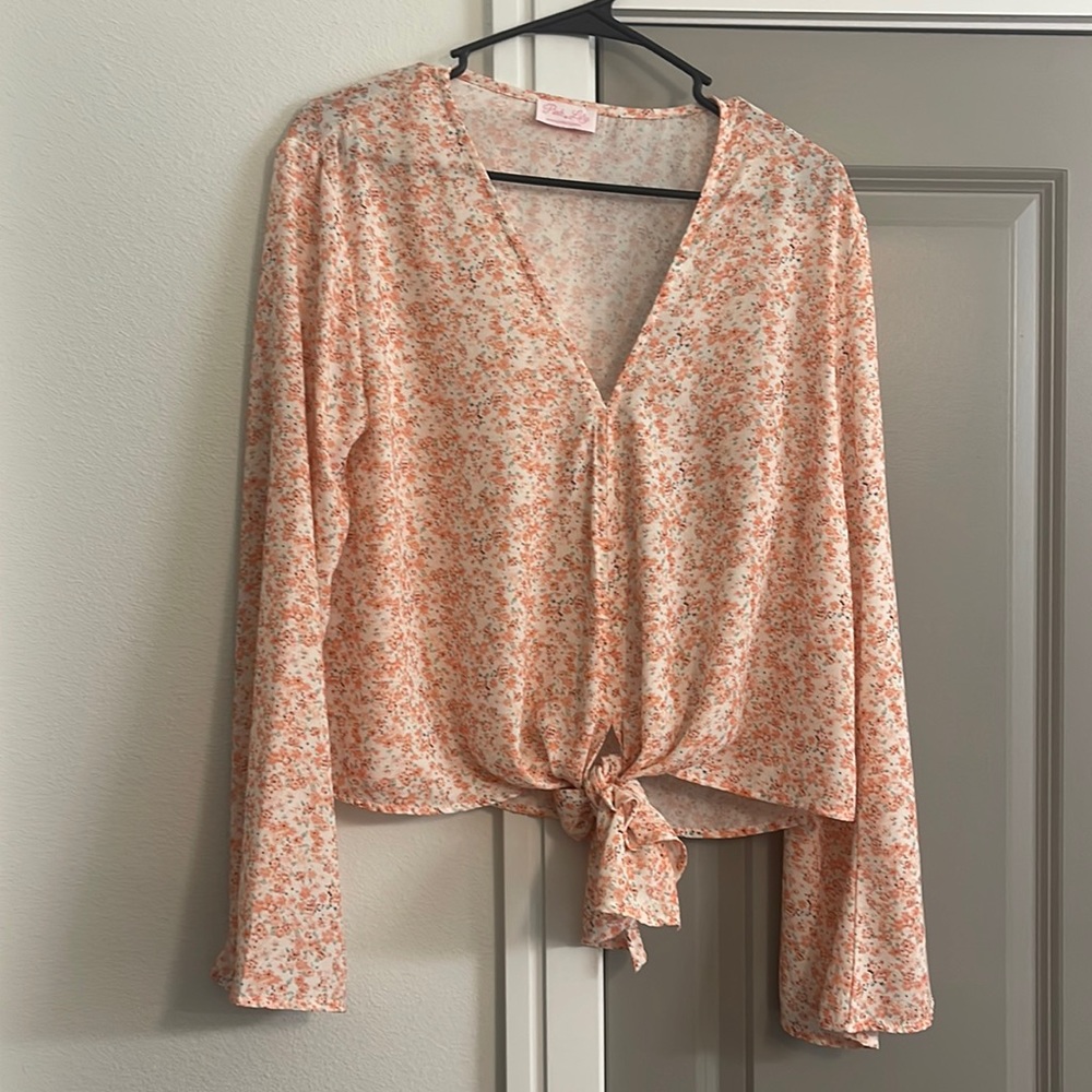 Pink Lily blouse with bell sleeves and floral pattern. Size Medium